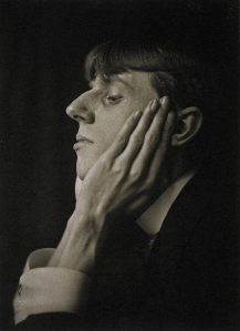 Frederick Evans - Retrato de Vincent Aubrey Beardsley (1894) - La imagen muestra una fotografía en blanco y negro en la que aparece el primer plano de perfil de un muchacho joven, con el pelo de color claro y cortado a la taza. Tiene una nariz ganchuda y prominente y apoya la mejilla en una mano grande y de dedos muy largos y huesudos. Pulse para ampliar.